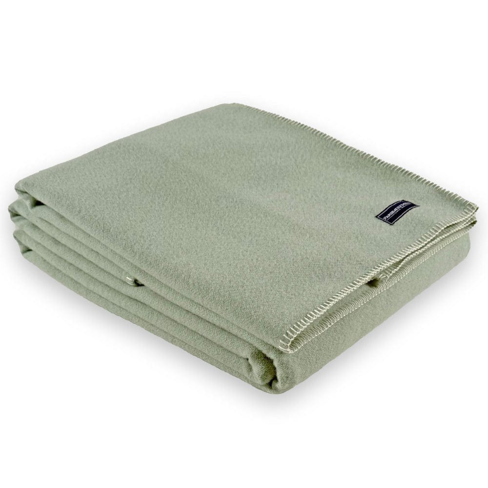 Faribault Mill Pure and Simple sea glass middleweight wool bed blanket, folded and displayed at an angle to highlight the thickness, loft of the wool, and whipstitched edges.
