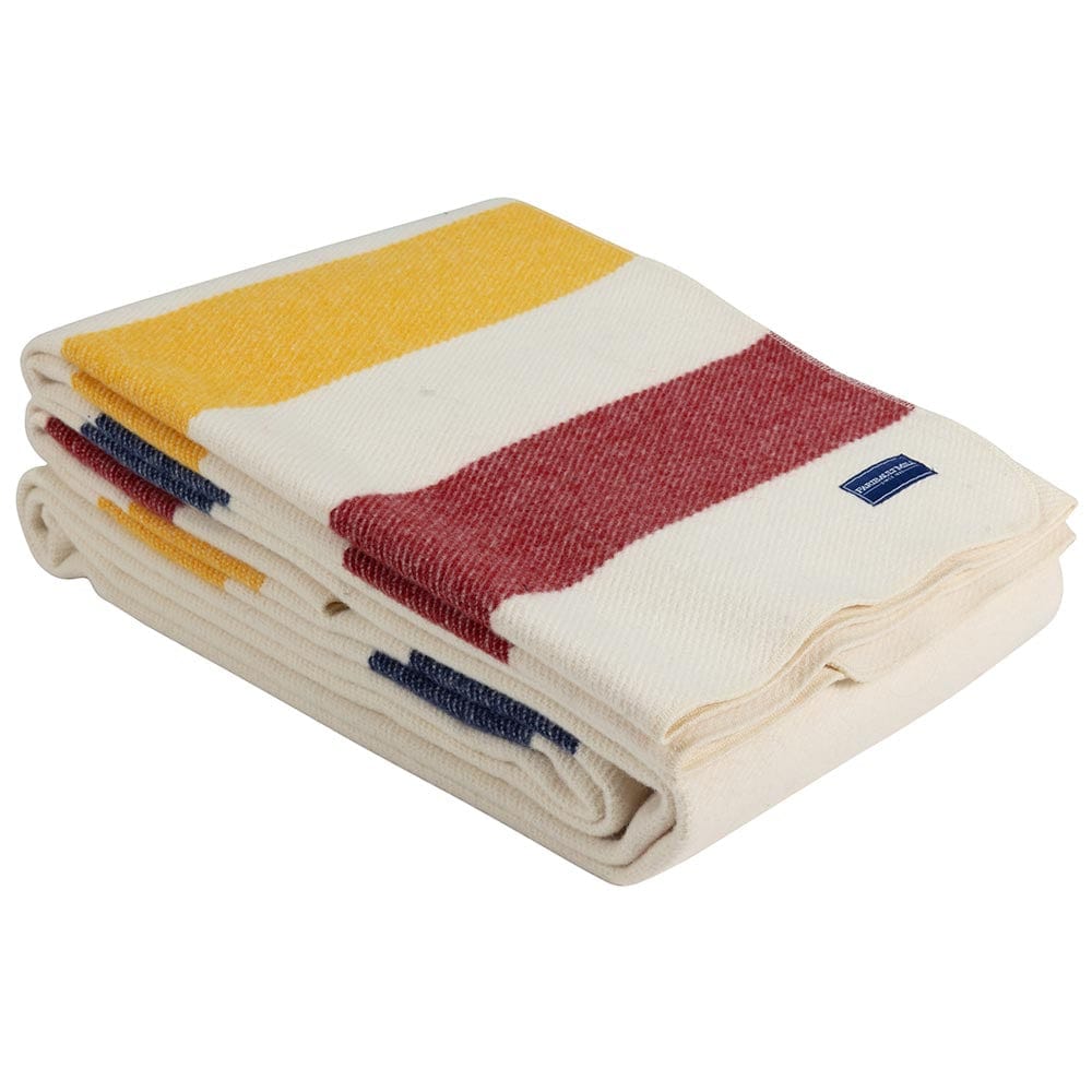 Faribault Mill Frontier natural heavyweight wool bed blanket, folded and displayed at an angle to highlight the thickness, loft of the wool, and whipstitched edges.