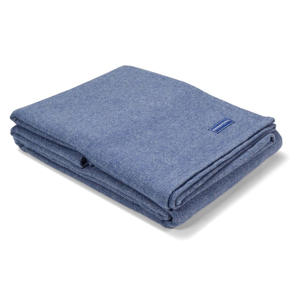 Faribault Mill Lakefront blue steel lightweight wool bed blanket, folded and displayed at an angle to highlight the thickness, loft of the wool, and whipstitched edges.