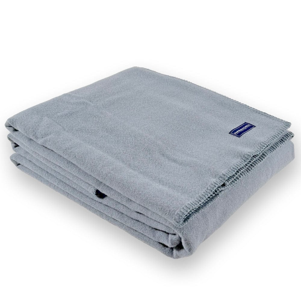 Faribault Mill Pure and Simple sky blue middleweight wool bed blanket, folded and displayed at an angle to highlight the thickness, loft of the wool, and whipstitched edges.