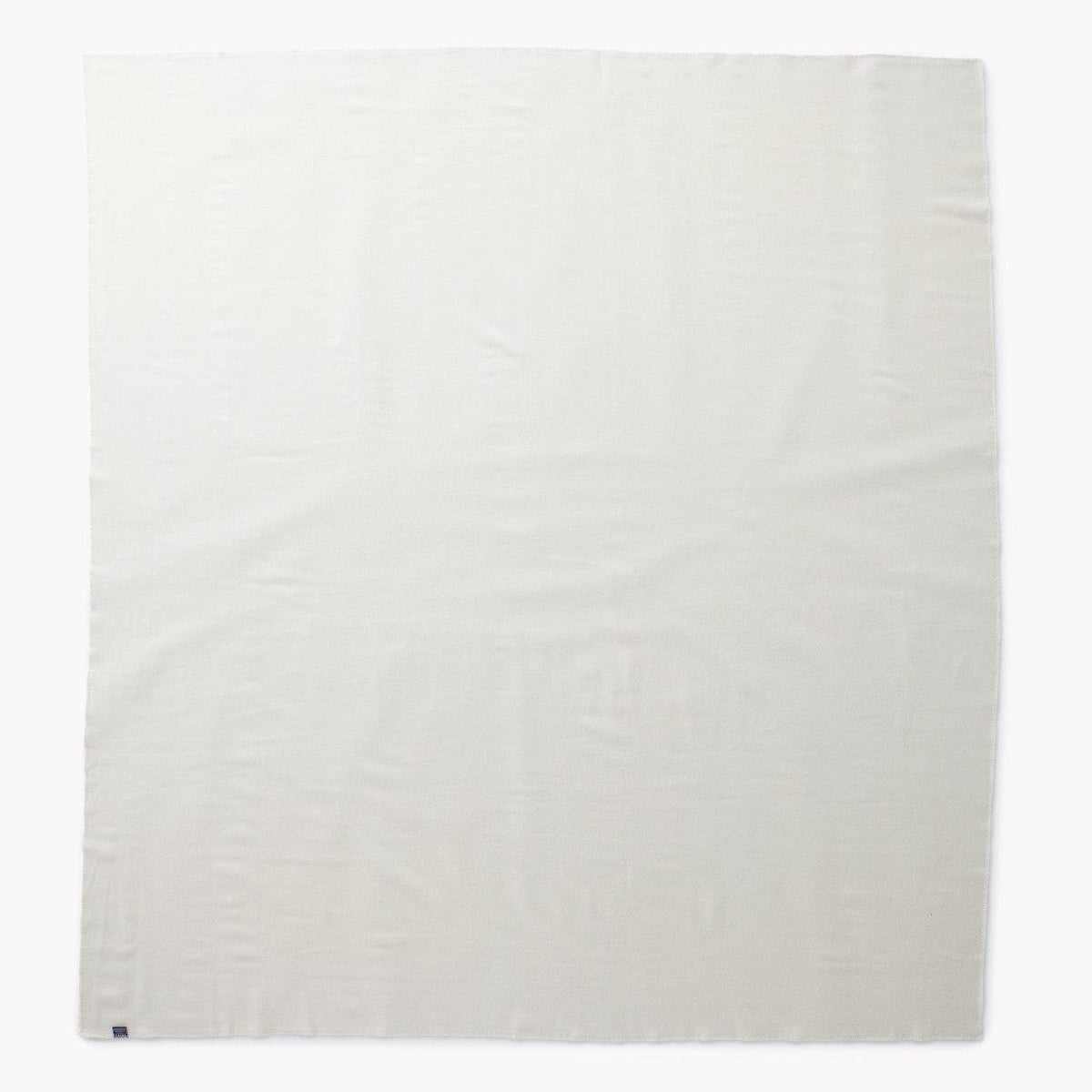 Faribault Mill Pure and Simple bone white middleweight wool bed blanket, unfolded and laid flat in a top-down view.